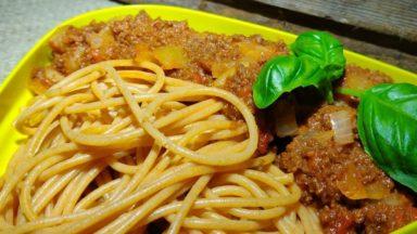 spagettia ja pastasoossia, päällä basilikan lehtiä