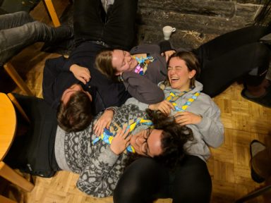 Kuva partiolaisia makaamassa ringissä tekemässä naurujoogaa