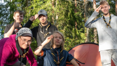 Partiolaisia metsässä teltan edessä